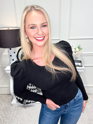 Classic black top with round neckline and puff sleeves.