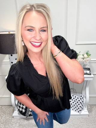 Black top with ruffle neckline and trim